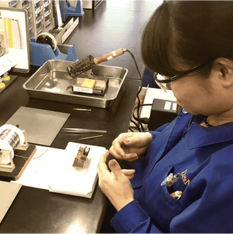 A woman building Hi-Fi equipment