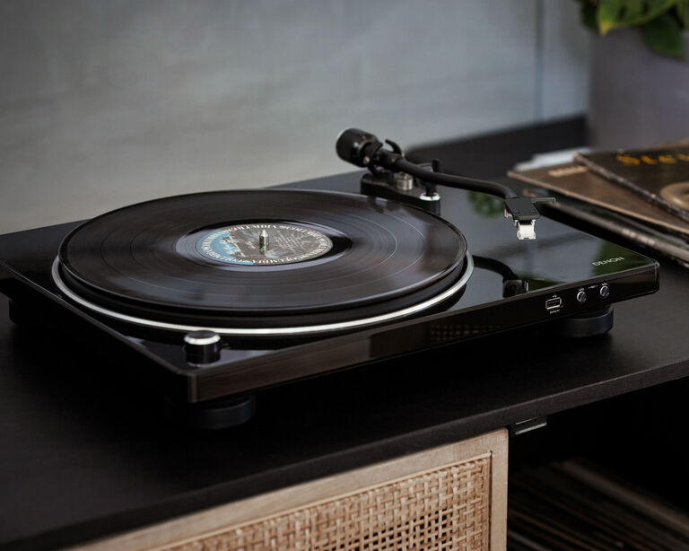 A Denon Turntable next to records