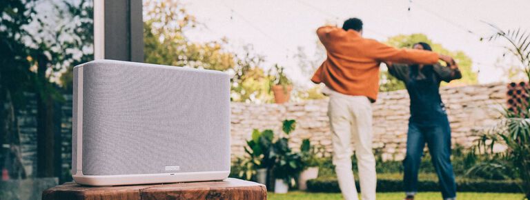 A speaker with a couple dancing in the background