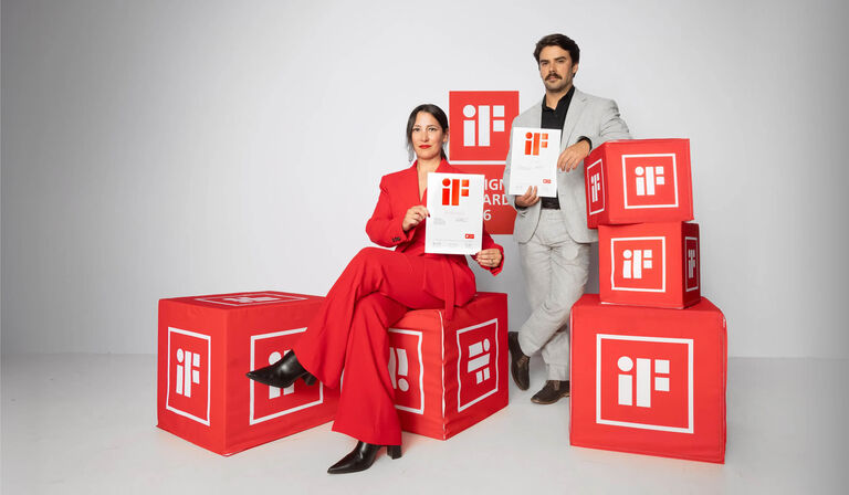Two people holding award certificates