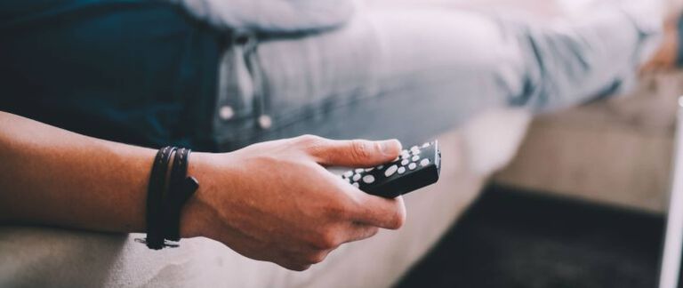 A man holding a TV remote