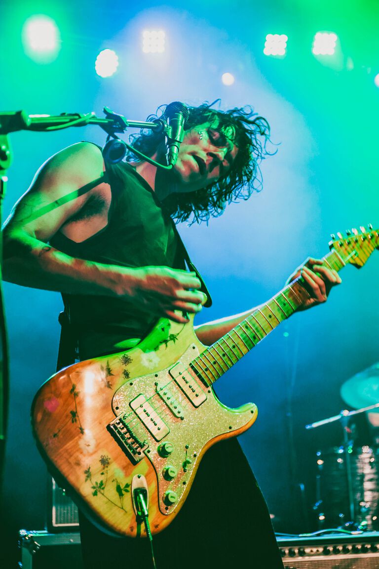 Nick Llobet playing a guitar on stage