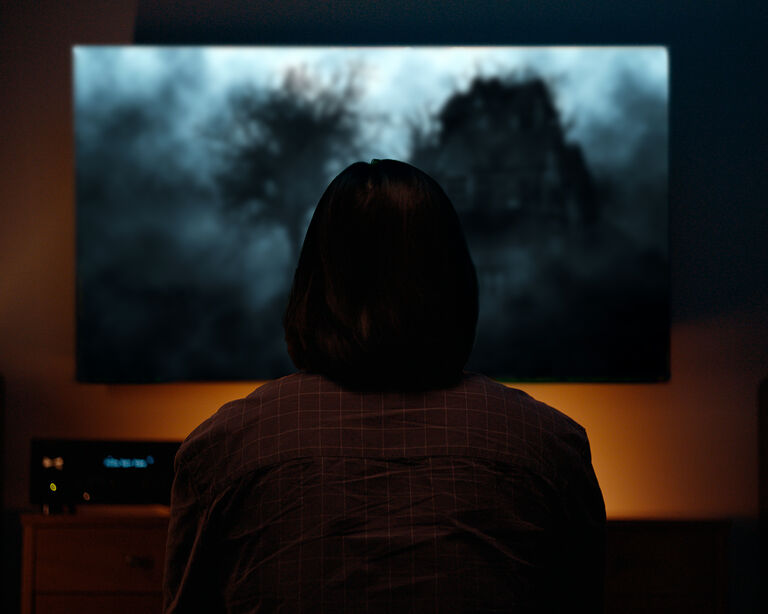 Woman watching a horror movie.