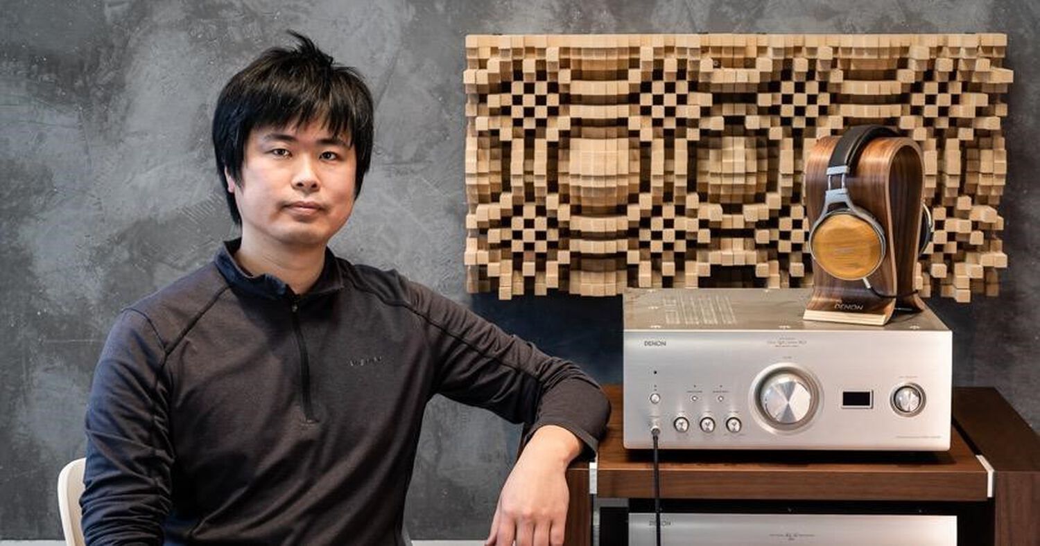 A man sitting next to Denon Headphones